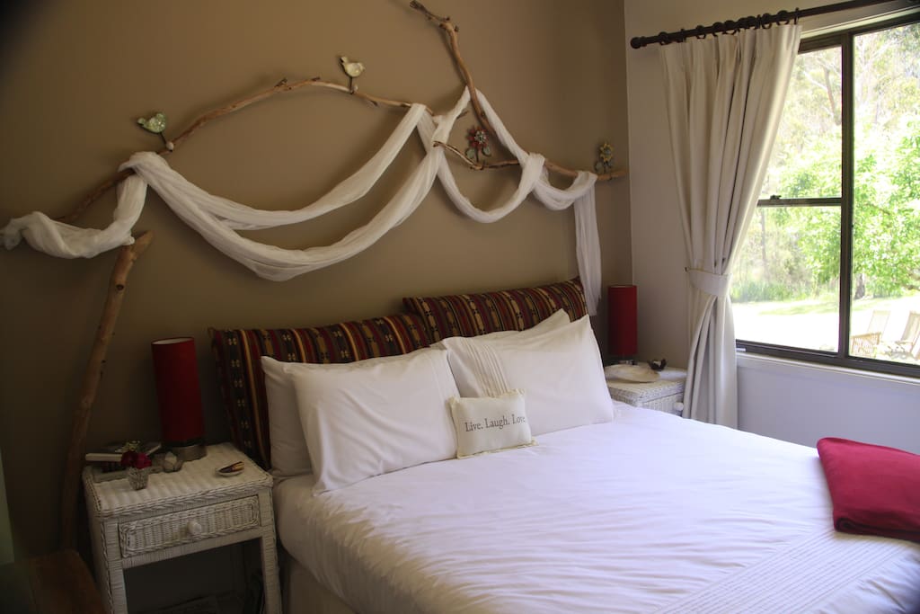 your room, with Persian cushions as a bedhead and unique wall feature