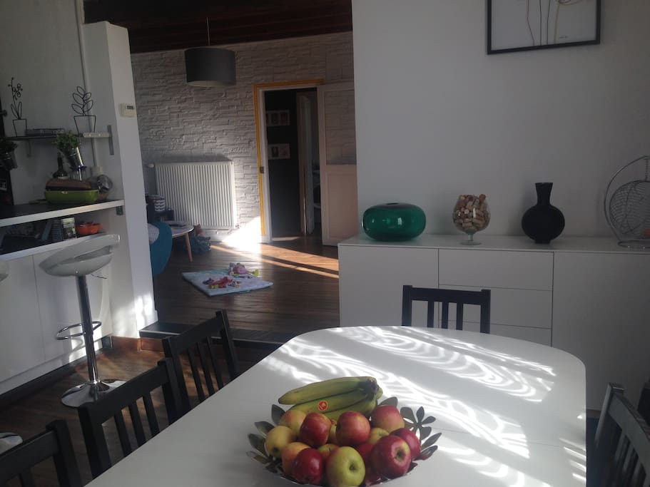 La salle à manger donnant sur la cuisine ouverte et le salon