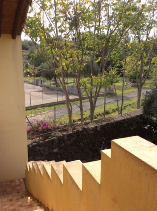 Staircase to upper floor where bedroom is located overloking the tennis court