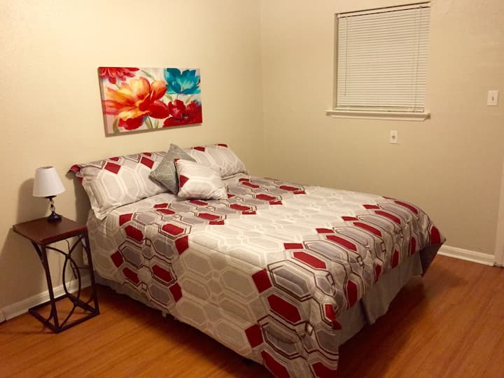 เตียงควีนไซส์ที่สะดวกสบายในห้องนอน 1 ชั้นล่าง คุณอาจเห็นเครื่องนอนและศิลปะบนผนังที่แตกต่างกันในขณะที่เราตกแต่งใหม่เป็นครั้งคราว 