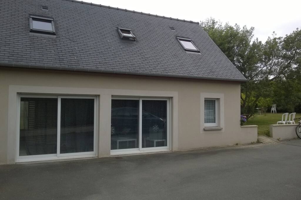 facade de la maison et on apercoit le jardin sur le coté. parking privatif devant le logement