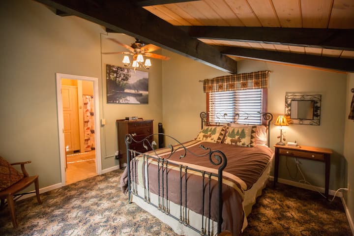 クイーンサイズのベッドとスイートバスルームを備えた上層階のベッドルームには、夏季用のエアコンユニットがあります。