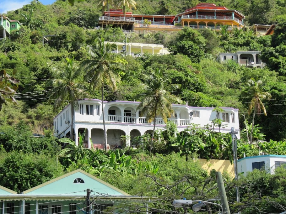 Villa is top left side of the white and purple home with the scalloped openings