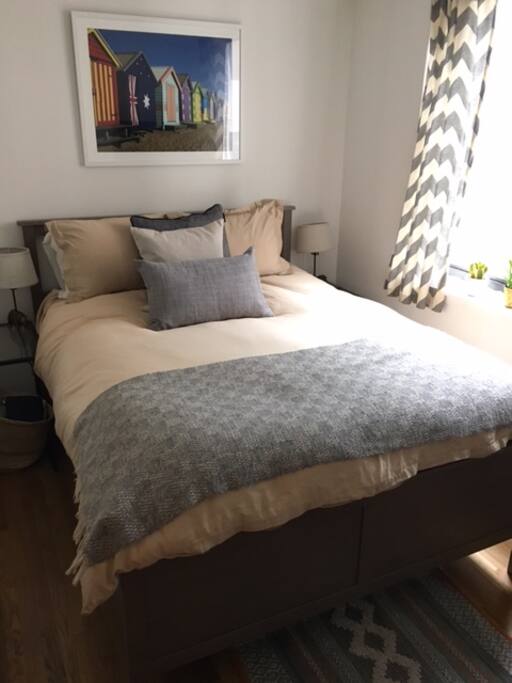 Cozy bedroom with queen bed, cable TV, sunny window.