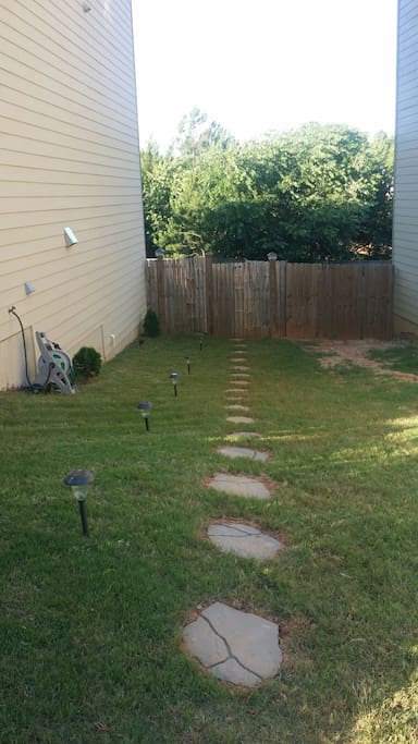 Follow the stepping-stones through the gate to the yellow door.