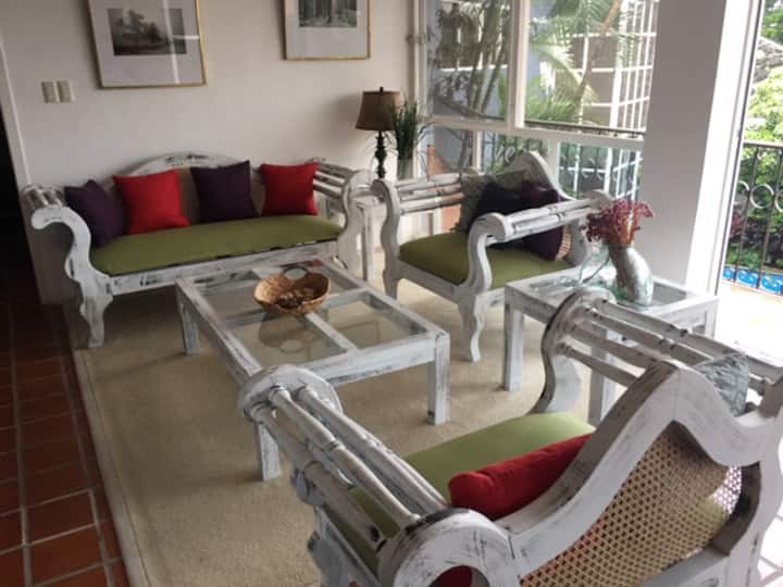 ห้องนั่งเล่นมองเห็นระเบียงและหน้าต่างบานเลื่อนสว่างมาก 