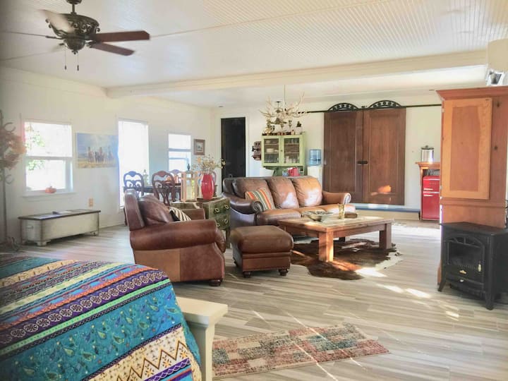 This side view is one of the queen beds and the living room leather furniture. The room is spacious enough for your party to enjoy. The views include local wildlife and our livestock, including friendly horse friends Adobe and Sally.