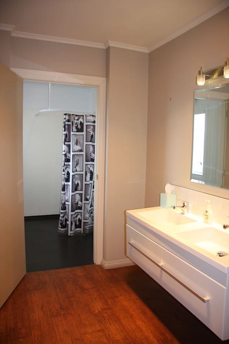 A large bathroom has double basin , shower room and separate toilet.