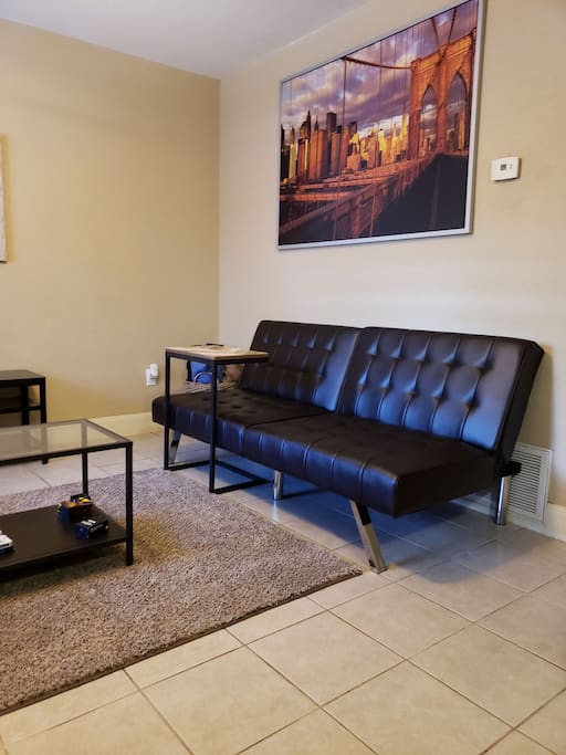 Living room with futon couch and small desk for work