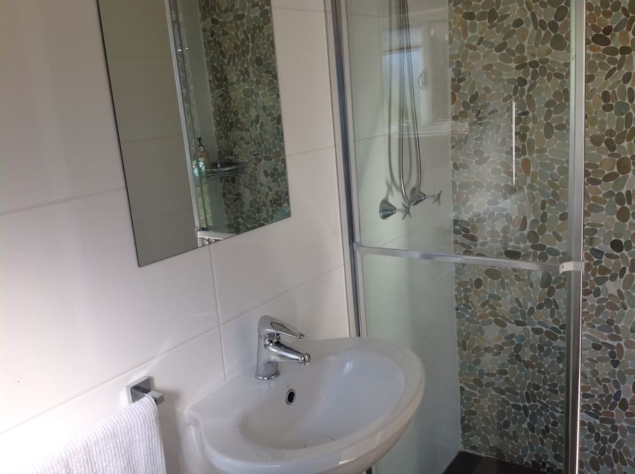 Tidy and clean bathroom with shower, toilet and basin