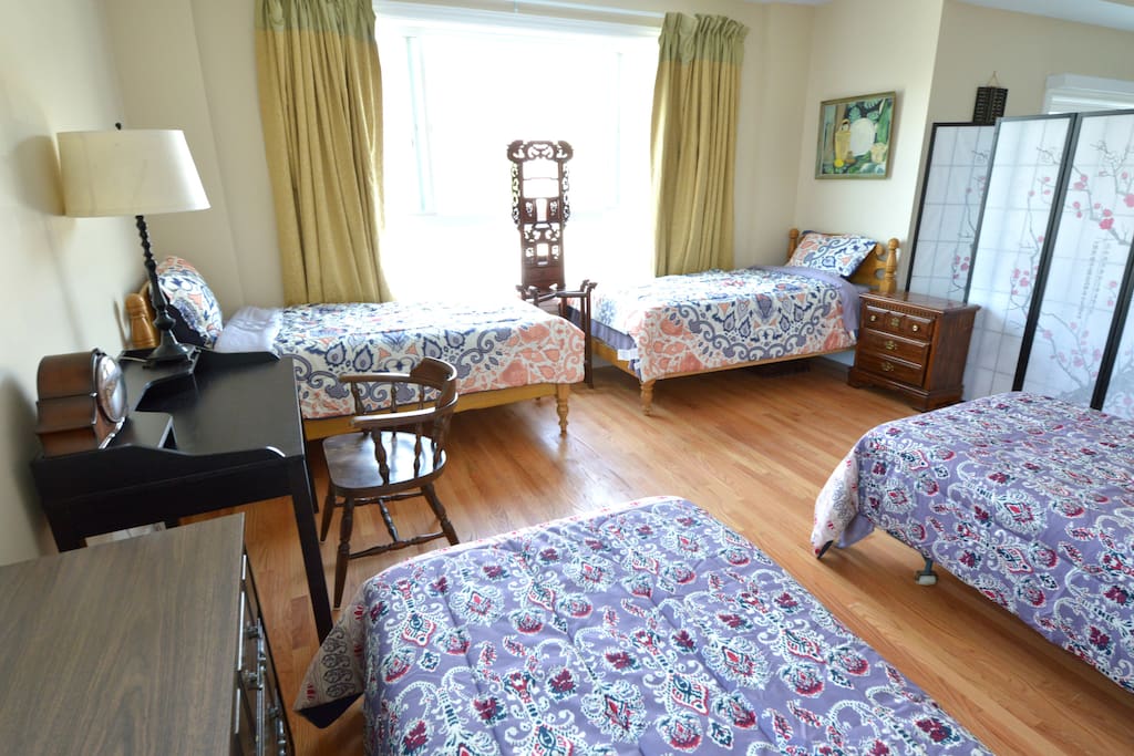 Four single beds, this previously living area is next to the dining room and kitchen, separated by room dividers