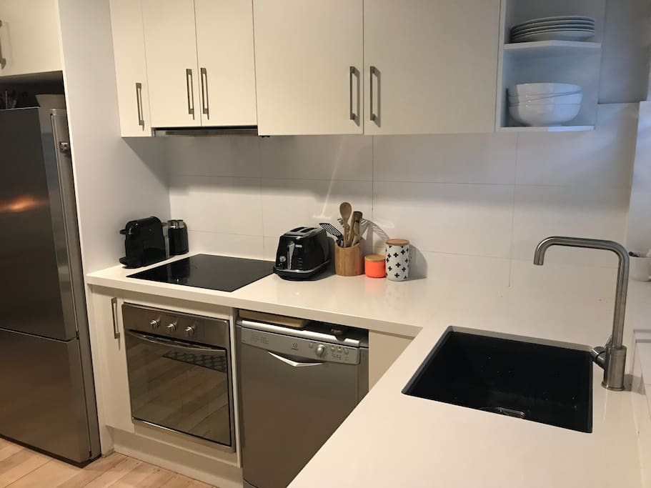 Kitchen with dishwasher, stainless steel large fridge & freezer, gas hot water, electric oven & cook top.