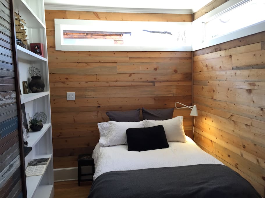 The bedroom wooden walls and high windows for nice light.