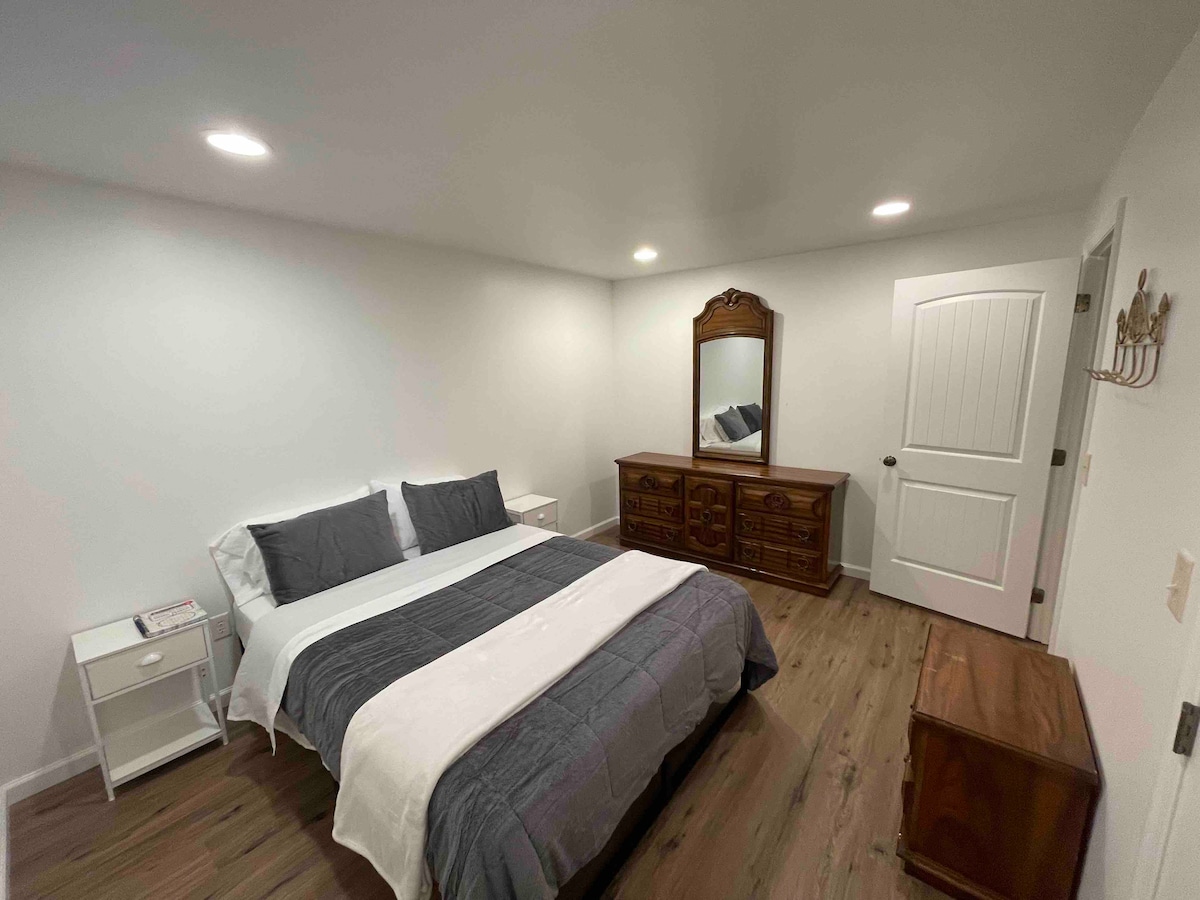 Spálňa v suteréne so šatníkom a komodou.