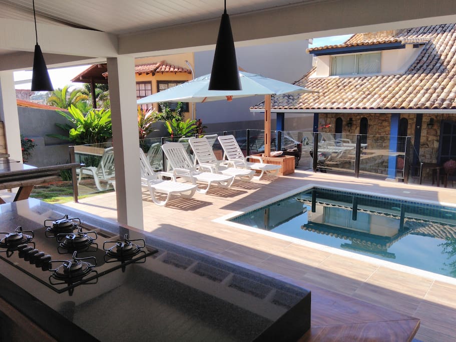 Vista do espaço gourmet para a piscina e varanda da casa
