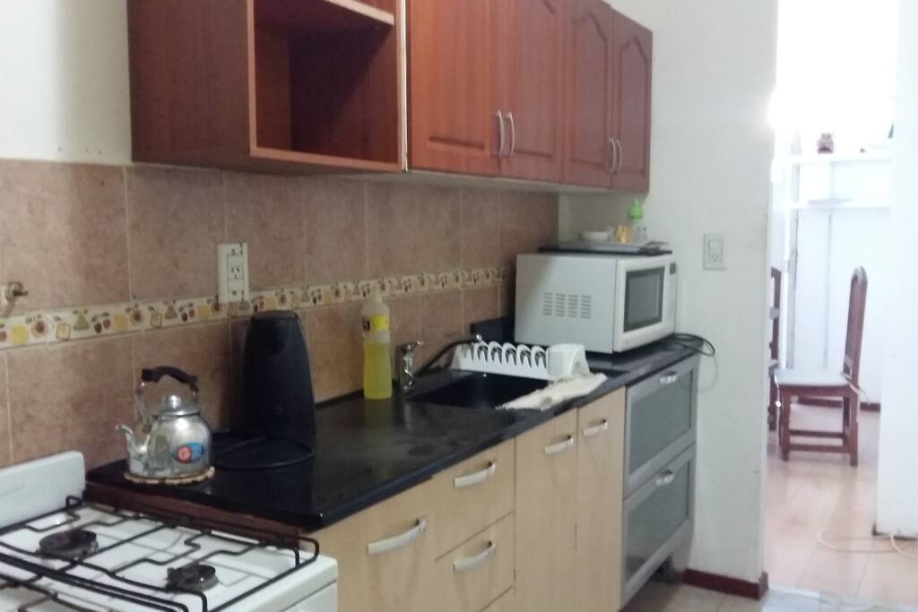Cocina equipada con vajilla ,microondas y pava eléctrica.