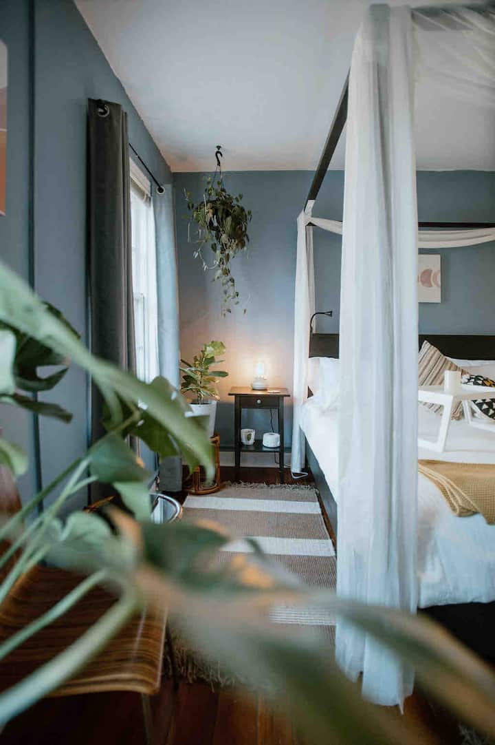 Spacious king suite with a 5-drawer dresser, full-length mirror, and a white noise machine to block out the street. Natural light, room to breathe.