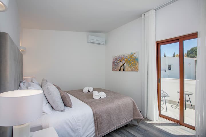 Segundo dormitorio con cama tamaño king, armarios empotrados con espejo de cuerpo entero y acceso al área del balcón.