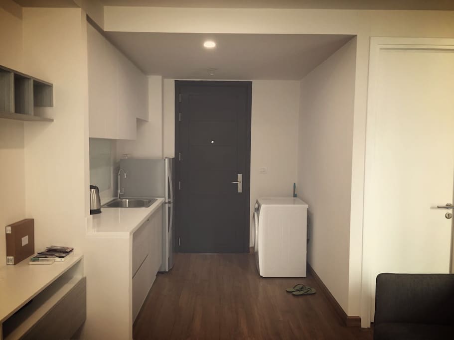 Kitchen with washing machine and refrigerator.