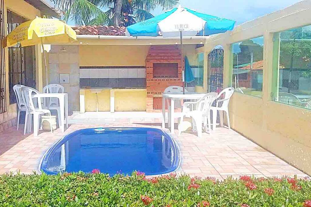 Uma piscina; uma churrasqueira, dois jogos de mesas e guarda- sóis.