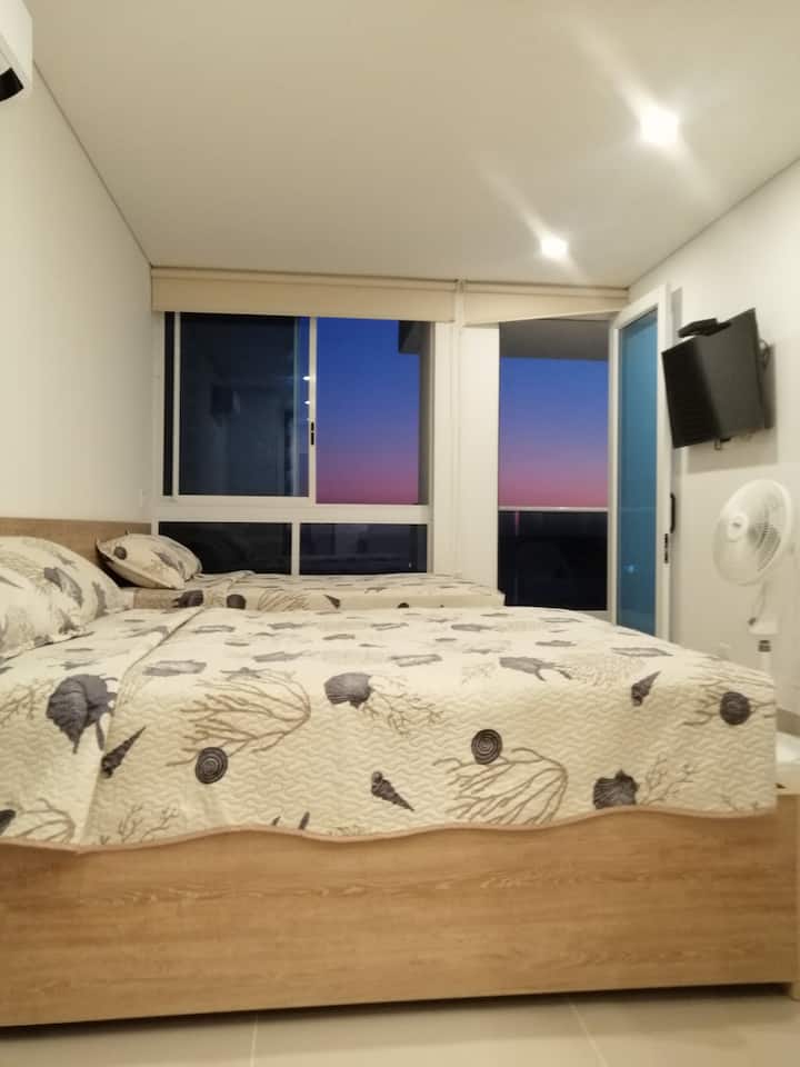 Habitación principal con 2 camas dobles, walking closet, aire acondicionado. Baño, salida al balcón con vista al mar y piscinas