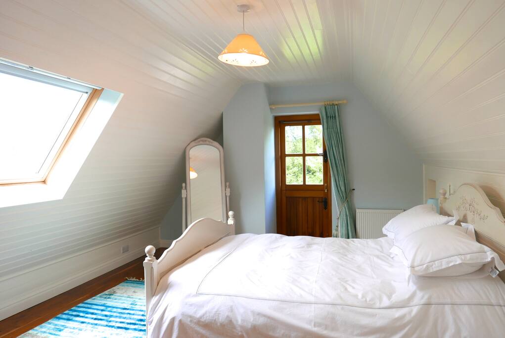 Master bedroom with views of the mountains and a private deck with steps to the garden.