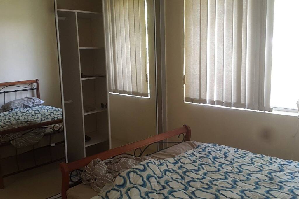 The bedroom with queen size bed and a large wardrobe