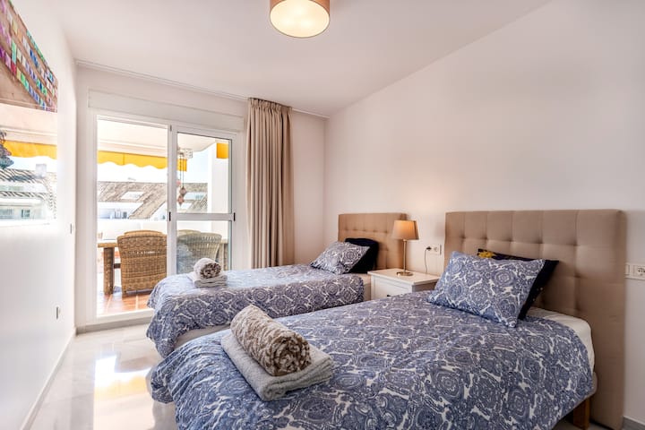 Спалня с две единични легла и плюшени завивки с директен достъп до терасата