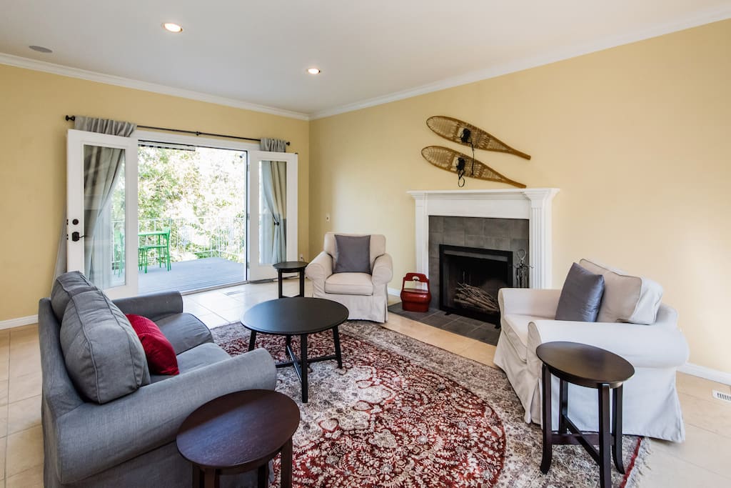 living room is set up for conversation. It has double doors to deck, tables, chairs, BBQ.