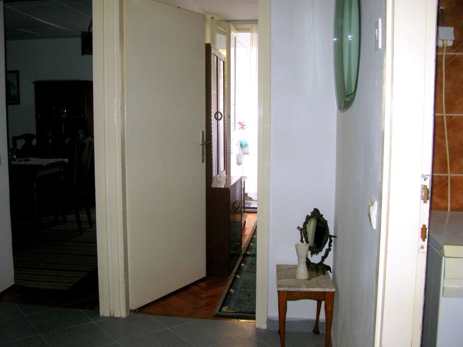 This photo is taken from the entrance and you can see half of the more or less square hallway. This hallway has access (doors) to each of the three rooms, bathroom and kitchen.