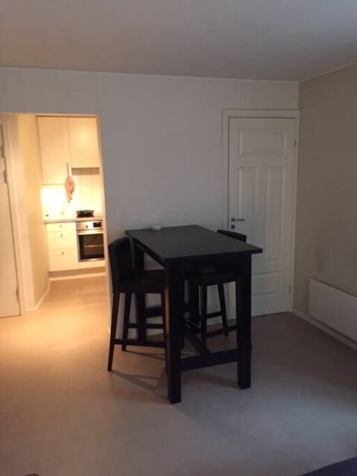 View from sofa to kitchen and eating area. Door to right into the one bedroom,
