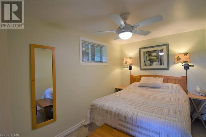 חדר שינה במפלס התחתון עם מיטת קווין סייז.