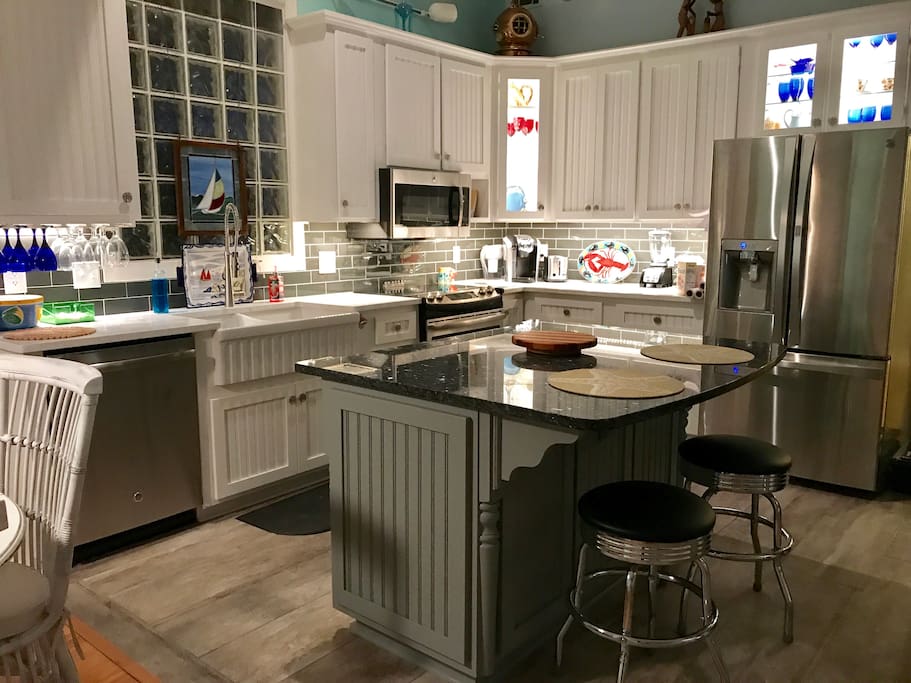 Tastefully furnished kitchen with all new appliances- stove, dishwasher, microwave, & refrigerator. Bar sits two people & adjacent dining table sits 5 or 6.