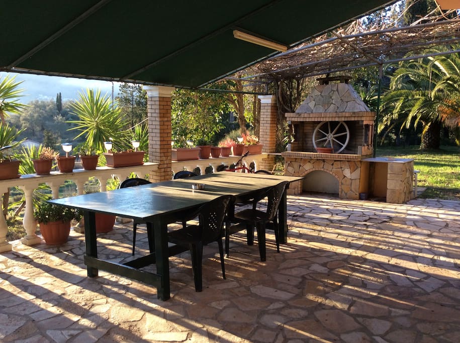 Porch with stone barbecue and large dining table