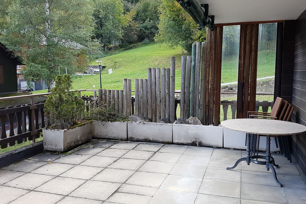 Sonnenterrasse mit Tisch und Stühlen, 2 Liegestühle und Gasgrill
