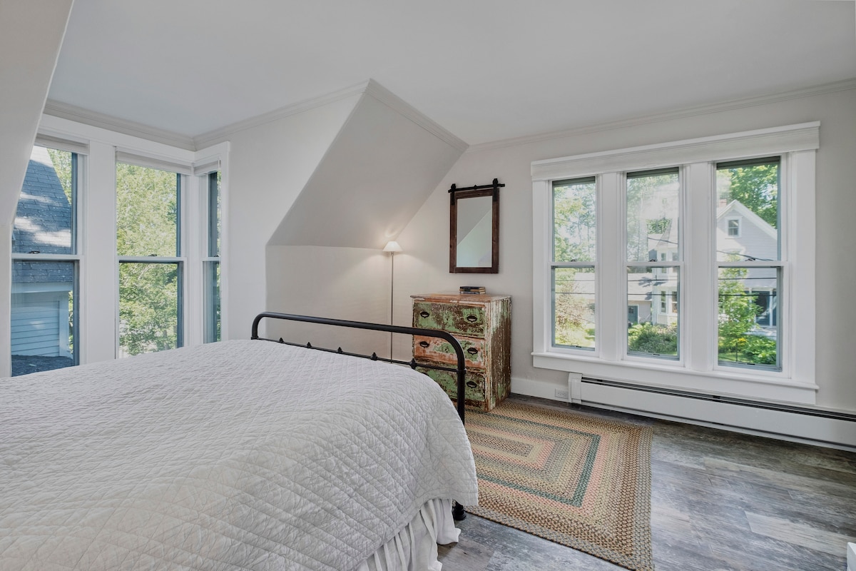 חדר שינה ראשי עם מיטת קווין סייז והרבה ארונות.