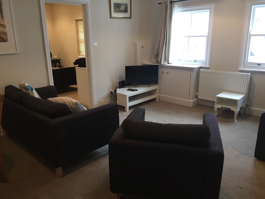 Sitting room area with sofa and armchair and TV