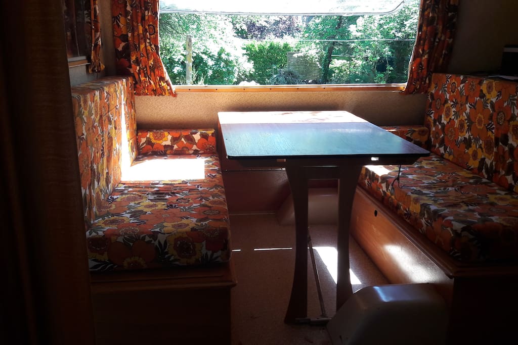 Caravane avec 4 couchages, réchaud, évier, auvent avec table et chaises.