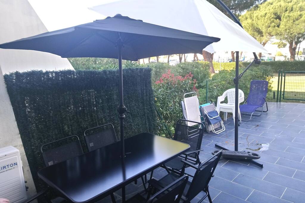 Table de jardin et ses chaises. Deux parasols.