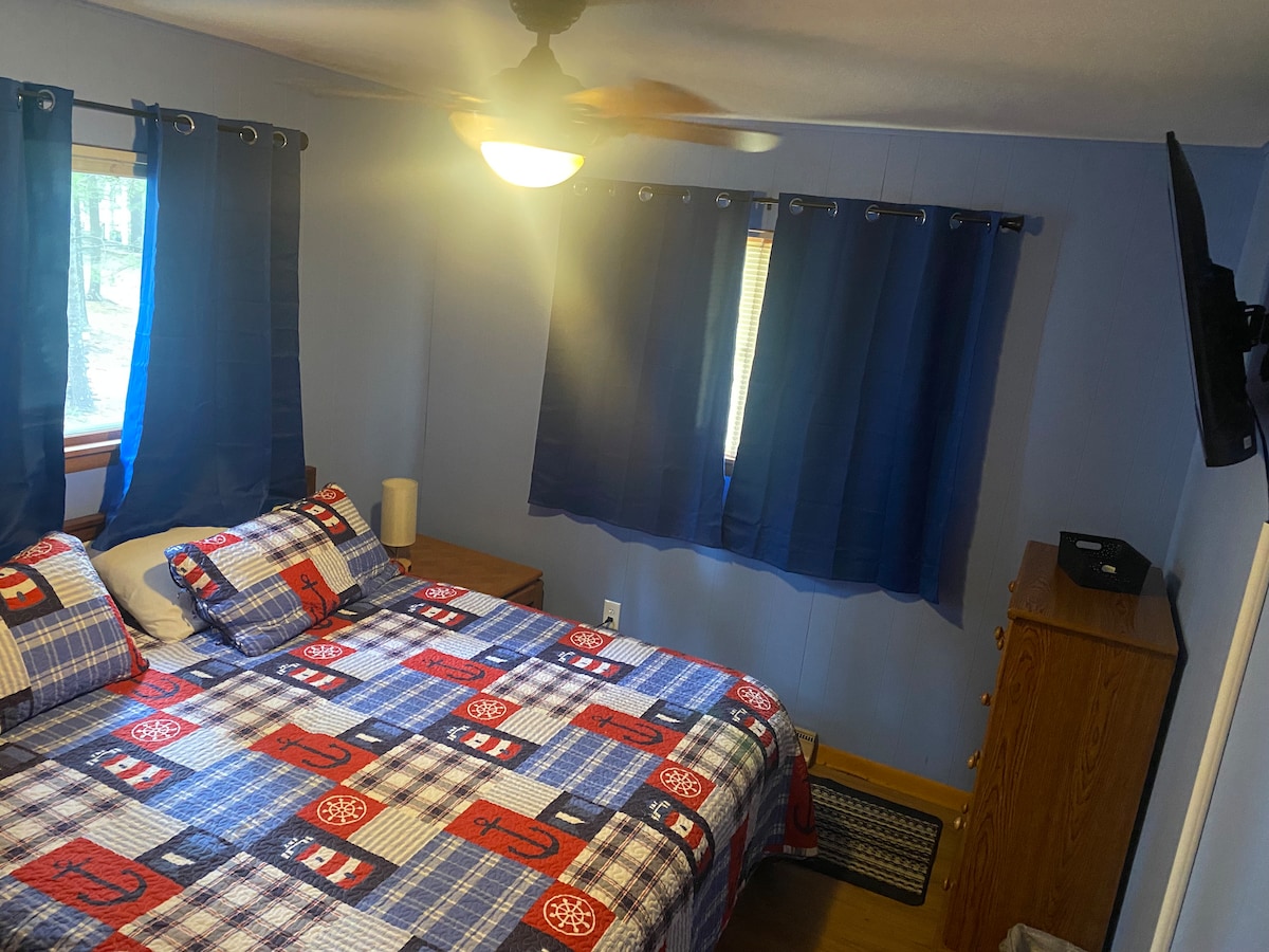 Habitación azul, espuma viscoelástica tamaño king, televisión, ventilador de techo, ventilador de techo y mesas auxiliares con lámparas y puertos telefónicos.  