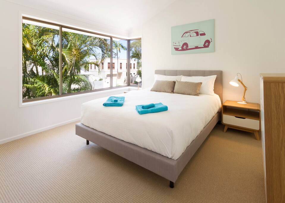 Main bedroom: Plush queen size bed with large double wardrobe and desk.
