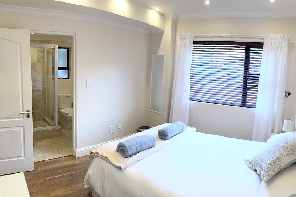 Separate bedroom with en-suite bathroom. Bedroom includes a dressing table with a hairdryer and cupboards with shelving and hangers.