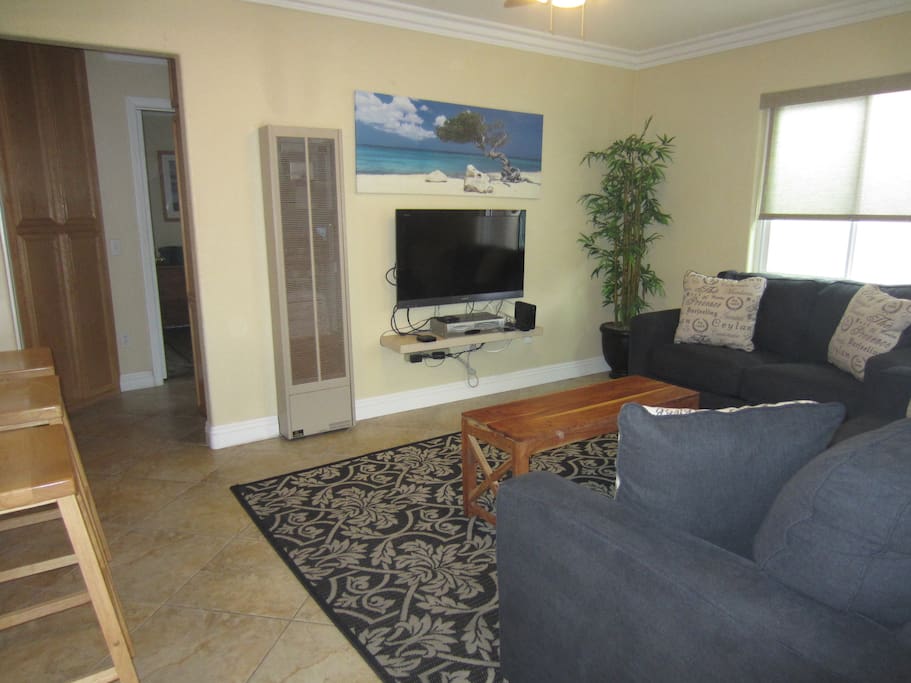 Living room off of kitchen w/TV and Apple device to access Netflix