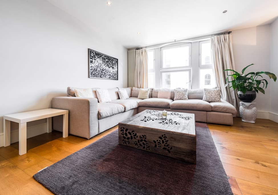 Spacious living area with lots of natural light and comfortable L shaped sofa