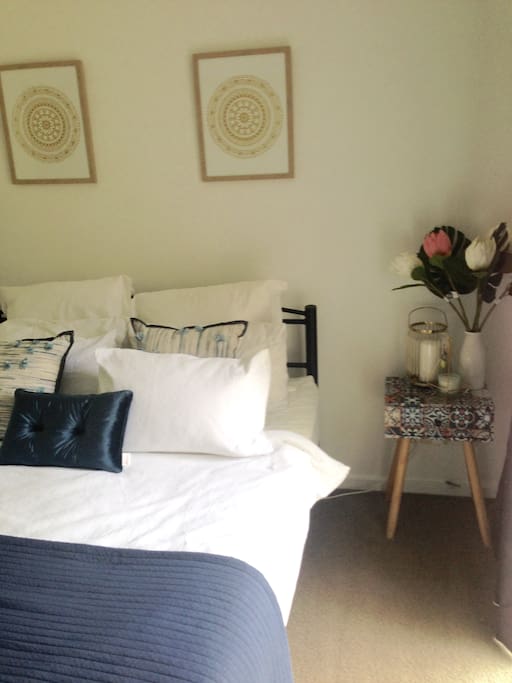 Garden view bedroom with queen bed includes built-in robe and TV.