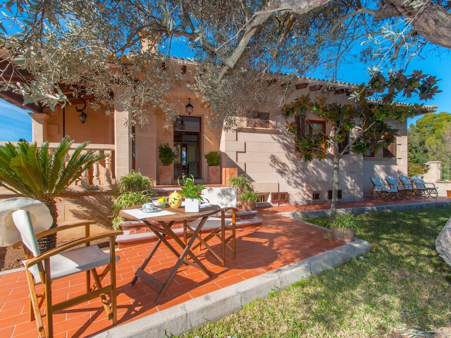 Encantador exterior de la casa con un jardín y butacas.