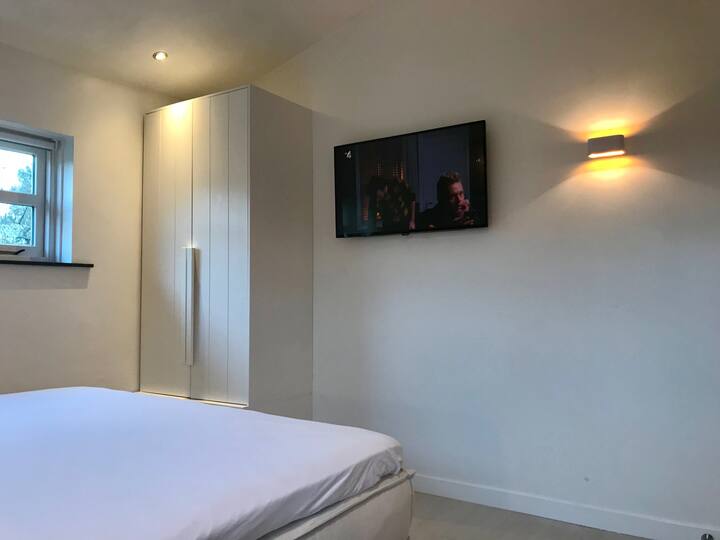 Master bedroom met kingbed en Smart TV