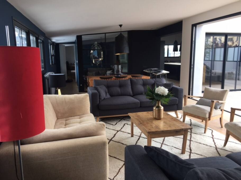 salon comprenant 3 grands canapés dans le prolongement, bureau avec verrière