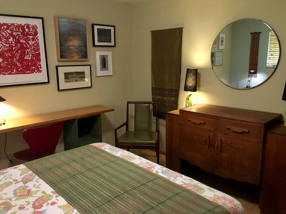 Guest bedroom with queen bed, desk, and closet