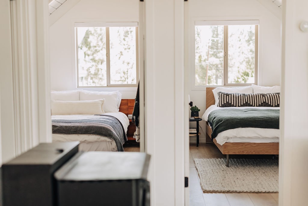 Our two upstairs bedrooms at the cabin (adjacent to the living-room) feature queen beds and modern furniture. 